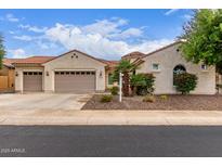 Charming single-story home with a three-car garage, desert landscaping, and a red tile roof at 27105 W Marco Polo Rd, Buckeye, AZ 85396