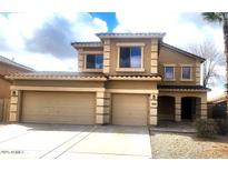 Two-story tan home featuring a spacious three-car garage and well-maintained landscaping at 3057 E Pinto Valley Rd, San Tan Valley, AZ 85143