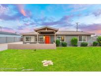 Charming single-story home featuring a well-manicured lawn and an inviting orange front door at 717 E Palmaire Ave, Phoenix, AZ 85020
