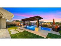 Inviting backyard pool with pergola, travertine deck, and outdoor living space at 8149 E Jaeger St, Mesa, AZ 85207