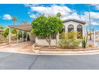 Charming manufactured home showcasing an attached carport and desert landscaping in a vibrant community at 111 S Greenfield Rd # 119, Mesa, AZ 85206