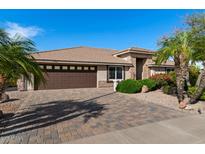 Charming single-story home featuring a tile roof, brick driveway, desert landscaping, and a two-car garage at 11342 E Laguna Azul Cir, Mesa, AZ 85209