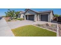 Stunning home featuring a three-car garage, a driveway with pavers, and easy-care desert landscaping at 11656 W Luxton Ln, Avondale, AZ 85323
