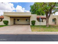 Tan single-story home featuring a covered parking space and manicured landscaping at 131 N Higley Rd # 51, Mesa, AZ 85205