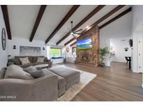 Inviting living room featuring vaulted ceilings, exposed beams, stone fireplace, and comfortable seating at 1444 E Myrna Ln, Tempe, AZ 85284