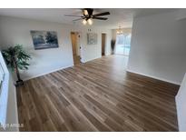 Bright living room with modern ceiling fan, wood-look flooring, and views to the backyard pool at 1545 W Marco Polo Rd, Phoenix, AZ 85027