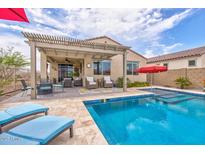 Backyard oasis featuring a pool, lounge chairs, outdoor seating, and a covered patio at 16139 S 178Th Dr, Goodyear, AZ 85338