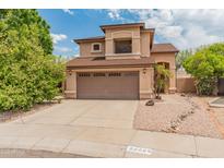 Two-story home featuring a two-car garage, desert landscaping, and a well-maintained front yard at 20809 N 1St Ave, Phoenix, AZ 85027