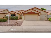 Inviting home with a two-car garage, low maintenance yard, and decorative architectural details at 4017 W Irma Ln, Glendale, AZ 85308