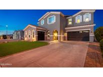 Stately two-story home featuring a three car garage, manicured lawn, and a tile roof at 6621 S Balboa Dr, Gilbert, AZ 85298