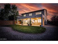 A backyard scene features a covered patio, a well-manicured lawn, and decorative landscaping at 6623 S Classic Way, Gilbert, AZ 85298
