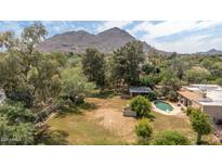 Expansive backyard with a sparkling pool, mature trees, and stunning mountain views at 6735 E San Juan Ave, Paradise Valley, AZ 85253