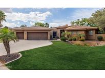 Beautiful home with a well-manicured lawn and a three-car garage at 844 E County Down Dr, Chandler, AZ 85249