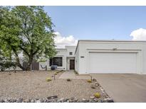 Charming single-story home with desert landscaping, a large tree, and a two-car garage at 1216 E Rowlands Ln, Phoenix, AZ 85022
