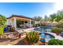 Beautiful backyard with pool, spa, covered patio, and lush landscaping, perfect for entertaining at 12798 W Dove Wing Way, Peoria, AZ 85383