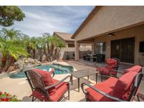 Inviting backyard pool with rock waterfall feature and covered patio seating area, perfect for outdoor entertaining at 12936 W Flower St, Avondale, AZ 85392
