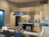 Bright kitchen with white cabinetry, stainless steel appliances, and a large center island with stone countertops at 15135 E Sundown Dr, Fountain Hills, AZ 85268