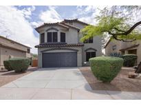 Charming two-story home featuring a well-maintained yard, a gray two-car garage and desert landscaping at 24709 N 75Th Way, Scottsdale, AZ 85255