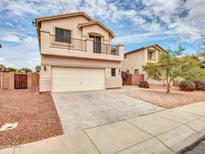 Charming two-story home features a balcony, two-car garage, and a driveway with desert landscaping at 3421 S 256Th Ave, Buckeye, AZ 85326
