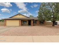 Charming single-story home with brick facade, neutral gravel landscaping, and mature shade tree at 4854 E Evergreen St, Mesa, AZ 85205