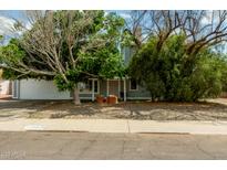 Charming home featuring mature landscaping, a two-car garage and covered front entry at 5923 W Mauna Loa Ln, Glendale, AZ 85306