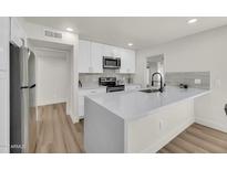 Bright kitchen features white cabinetry, stainless steel appliances, and a large island perfect for entertaining at 703 E Corte Oro --, Phoenix, AZ 85020