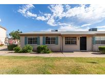 Charming single-story home featuring blue shutters and well-manicured landscaping at 849 N Revere -- # E, Mesa, AZ 85201