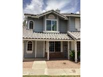 Charming two-story home featuring arched windows, tile roof, and an inviting covered entryway for a welcoming curb appeal at 860 N Mcqueen Rd # 1058, Chandler, AZ 85225