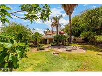 Lush backyard featuring mature trees, green grass, patio area with outdoor furniture, and an inviting atmosphere at 9430 S 47Th Pl, Phoenix, AZ 85044
