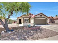 Charming single-story home with a well-manicured yard, desert landscaping, and cozy front porch at 13443 W Post Dr, Surprise, AZ 85374