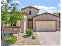 Charming single-Gathering home with stone accents, desert landscaping, and a two-car garage at 1895 N 141St Ave, Goodyear, AZ 85395