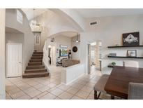 Open-concept living space with staircase, dining area, and living room, featuring tile floors and neutral tones at 20440 N 39Th Dr, Glendale, AZ 85308