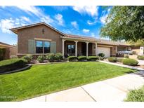 Charming single-story home with a well-manicured lawn and covered porch at 20585 W Garden St, Buckeye, AZ 85396