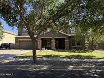 Charming two-story home featuring a well-manicured lawn, stone accents, and a spacious driveway at 2735 E Flower Ct, Gilbert, AZ 85298