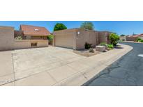 Home exterior features a two-car garage, large driveway, and low-maintenance landscaping at 4033 E Larkspur Dr, Phoenix, AZ 85032