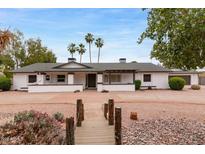 Charming ranch home with desert landscaping, mature palm trees, and unique walkway to front door at 4107 E Fairview Cir, Mesa, AZ 85206