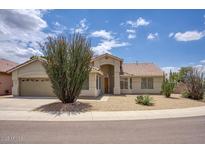 Tan home featuring low maintenance desert landscaping, an arched entryway, and a two-car garage at 4141 W Potter Dr, Glendale, AZ 85308