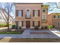 Charming two-story townhome with shuttered windows and small decorative balconies in a well-kept community at 5757 S 21St Ter, Phoenix, AZ 85040