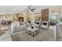 Spacious living room with a stone fireplace, neutral decor, and ample natural light at 616 E Lavitt Ln, Phoenix, AZ 85086