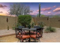 Cozy patio with a dining table surrounded by lush desert landscaping and a private wall at 7144 E San Cristobal Way, Gold Canyon, AZ 85118