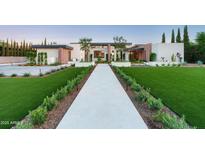 Striking modern home featuring a manicured lawn, geometric landscaping and an inviting stone walkway at 7341 E Sunnyside Dr, Scottsdale, AZ 85260