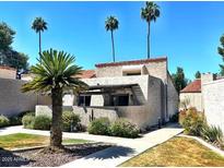 Well-maintained exterior of a home with a stucco wall, palm trees, and desert landscaping at 7409 N Via Camello Del Norte -- # 138, Scottsdale, AZ 85258