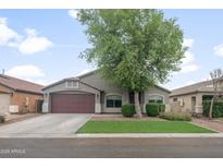 Charming single-story home with a well-maintained front yard and two-car garage under a partly cloudy sky at 1015 E Penny Ln, San Tan Valley, AZ 85140