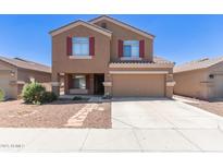 Charming two-story home features a two-car garage and well-maintained front yard with stone pathway at 10745 W Taft St, Phoenix, AZ 85037