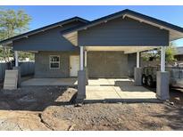 An exterior shot of a home featuring stucco walls, covered parking and fresh concrete at 1110 E Pierce St, Phoenix, AZ 85006