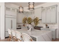 Bright kitchen features light gray cabinetry, quartz countertops, and an island with seating at 12366 N 129Th St, Scottsdale, AZ 85259