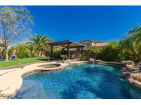 Resort-style backyard with sparkling pool, spa, covered patio, and lush landscaping, perfect for outdoor entertaining at 1453 E Elgin Pl, Chandler, AZ 85225