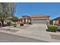 Single-story home featuring a desert-style landscape, a two-car garage, and a terracotta roof in a sunny setting at 16874 W Tonbridge St, Surprise, AZ 85374