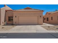 Tan home featuring a two car garage, desert landscaping and a tile roof at 18650 N 91St Ave # 3301, Peoria, AZ 85382
