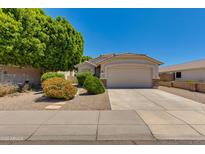 Charming single-story home featuring a two-car garage, a well-manicured lawn, and mature trees at 19851 N 35Th St, Phoenix, AZ 85050